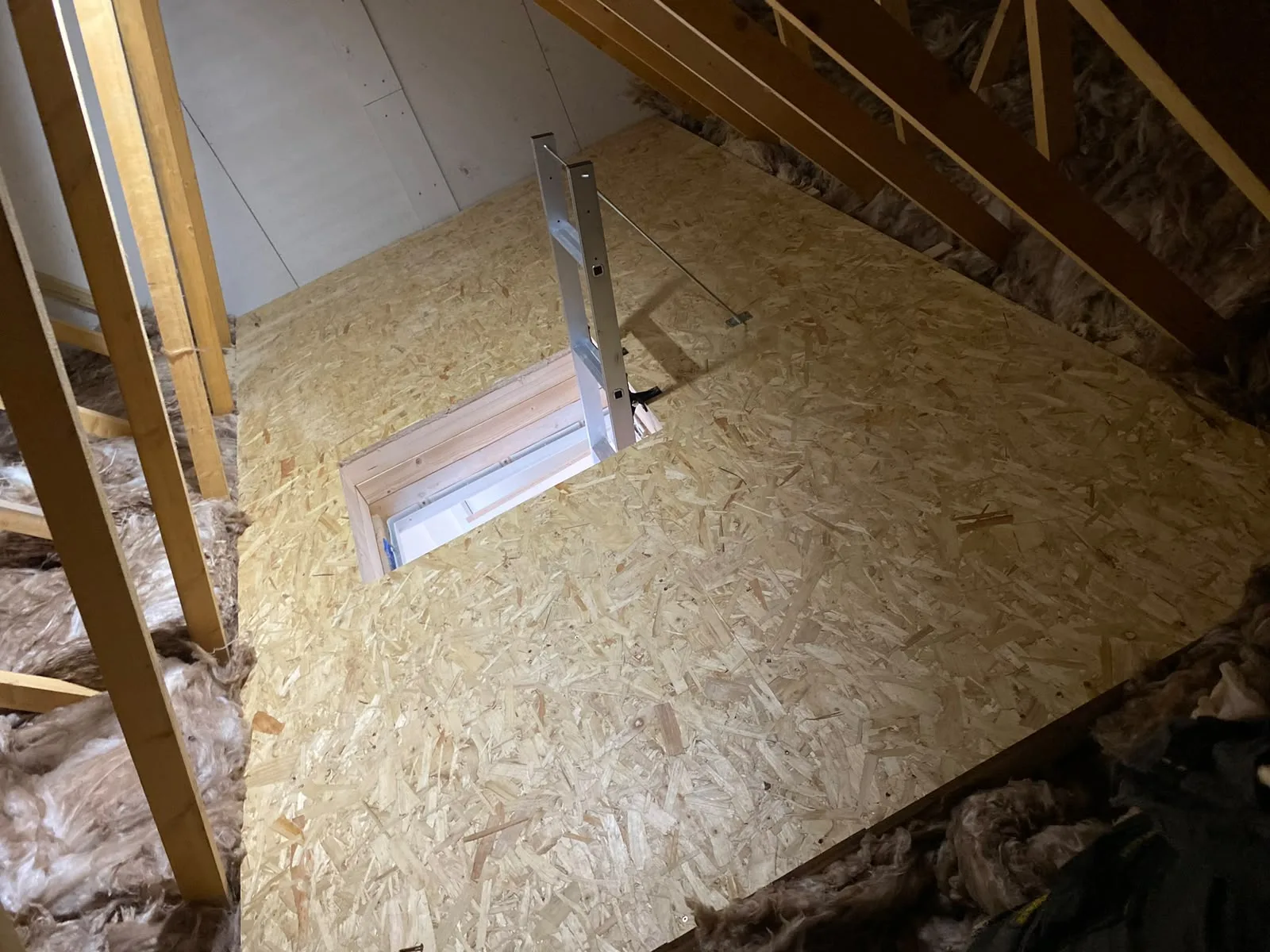 Finished loft boarding with a newly fitted hatch and ladder frame