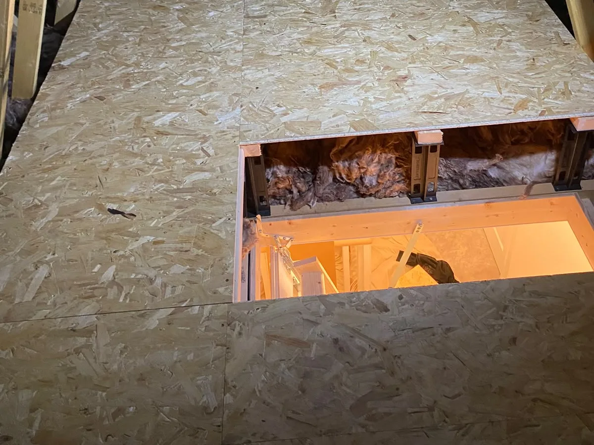 Cut-away at the hatch showing the raised sub-frame holding the deck clear of the insulation, which stays lofted underneath