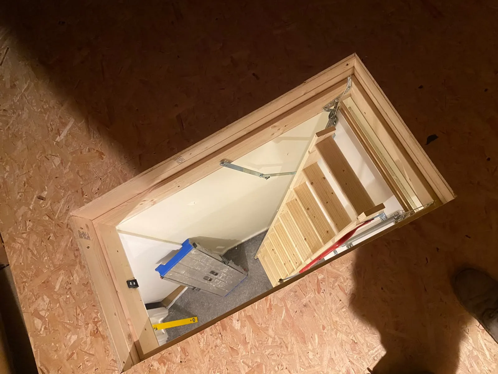 Looking down through an open loft hatch onto the boarded deck