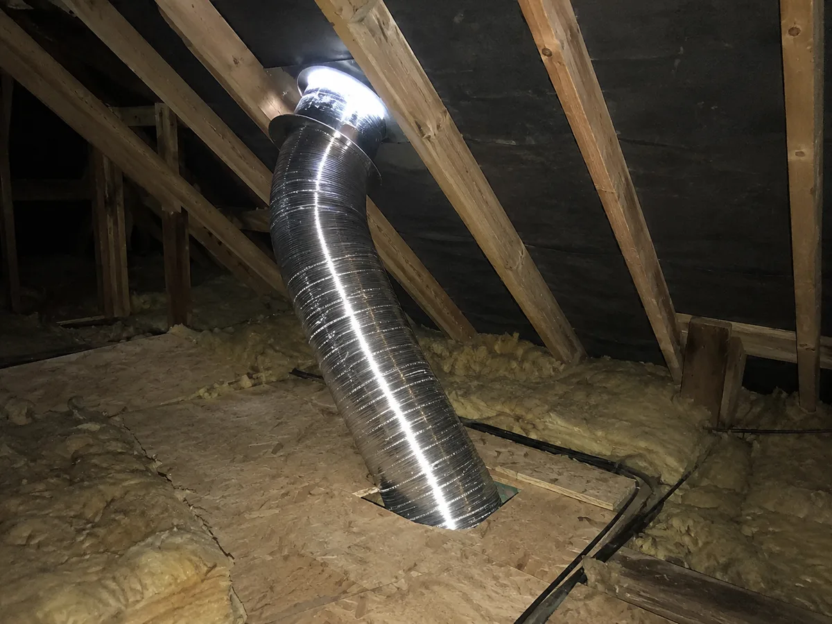 Reflective sun tunnel running from the roof slope down through the boarded loft floor