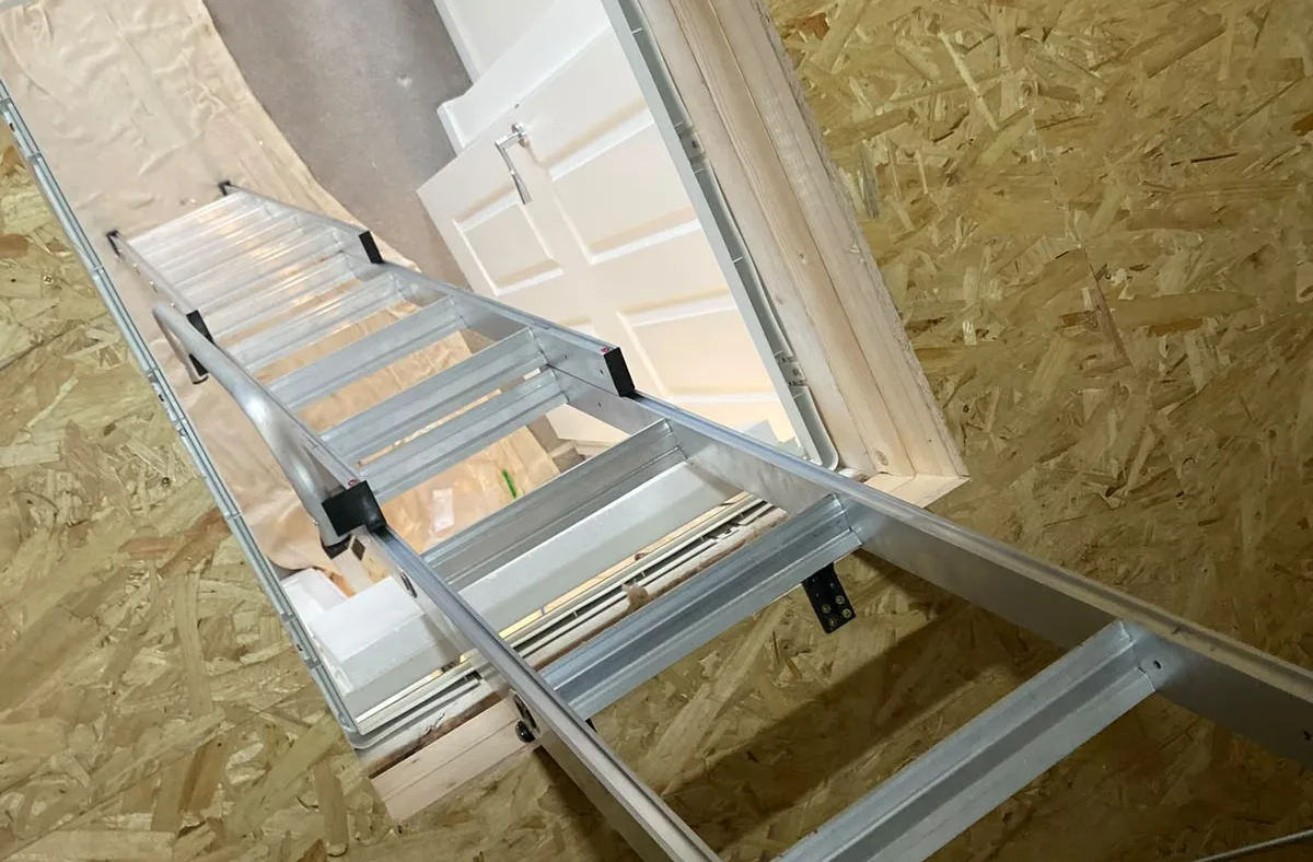 Aluminium loft ladder extending down through an open hatch to the landing below
