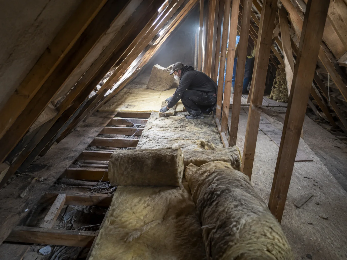Insulation being laid across loft joists in a roof space