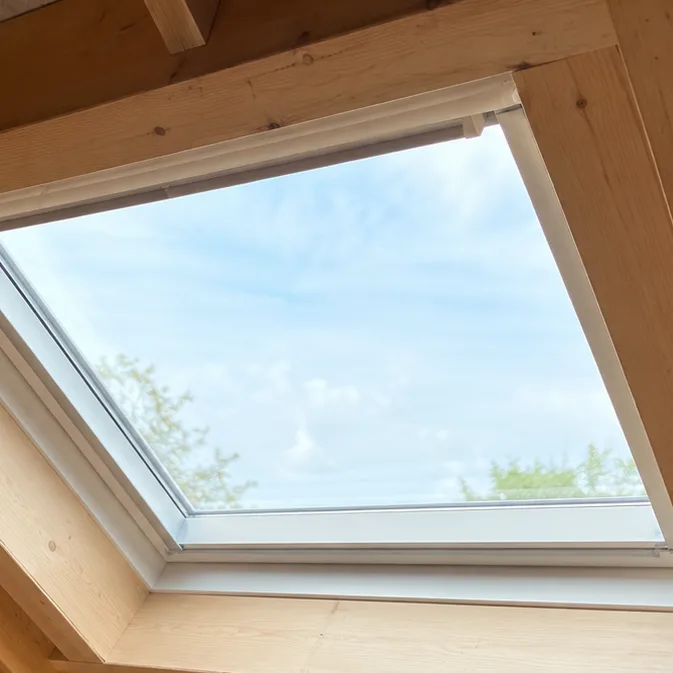 Close-up of a roof window frame and timber reveal from inside the loft