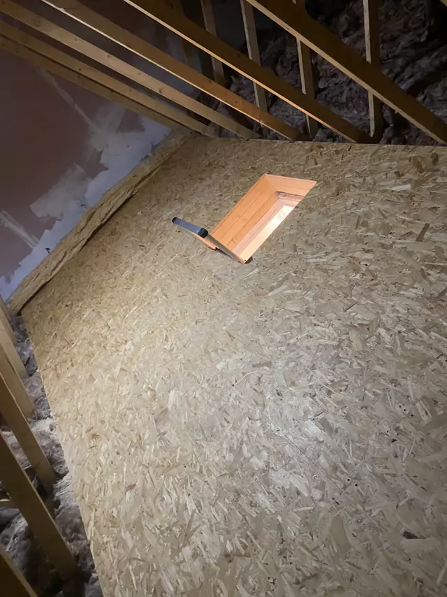 Boarding laid round a timber-lined hatch, insulation left clear at the eaves