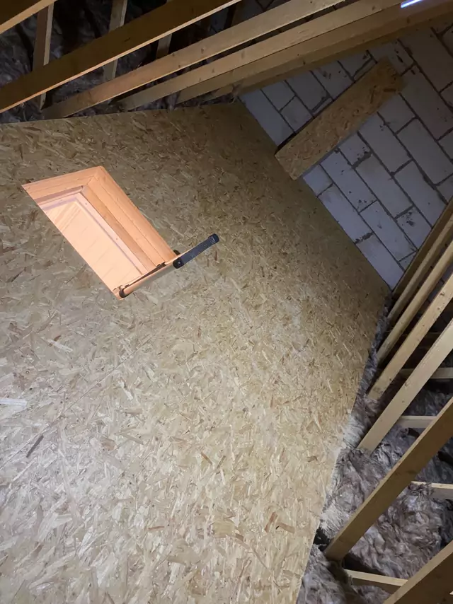 Timber-lined hatch opening framed into a boarded loft floor