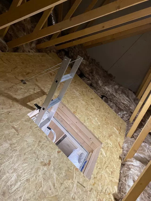 Loft ladder folded up through a hatch in the new boarded floor