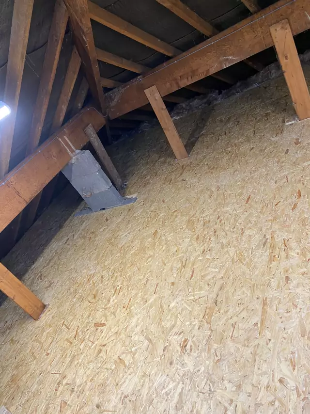 Fresh boarding across a loft beside the chimney stack