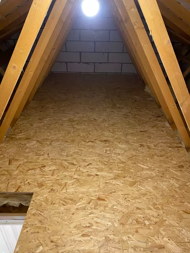 Boarding up to the blockwork gable between trusses