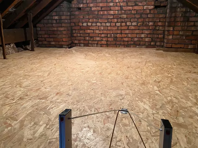 Large boarded loft up to a red-brick gable, ladder at the hatch