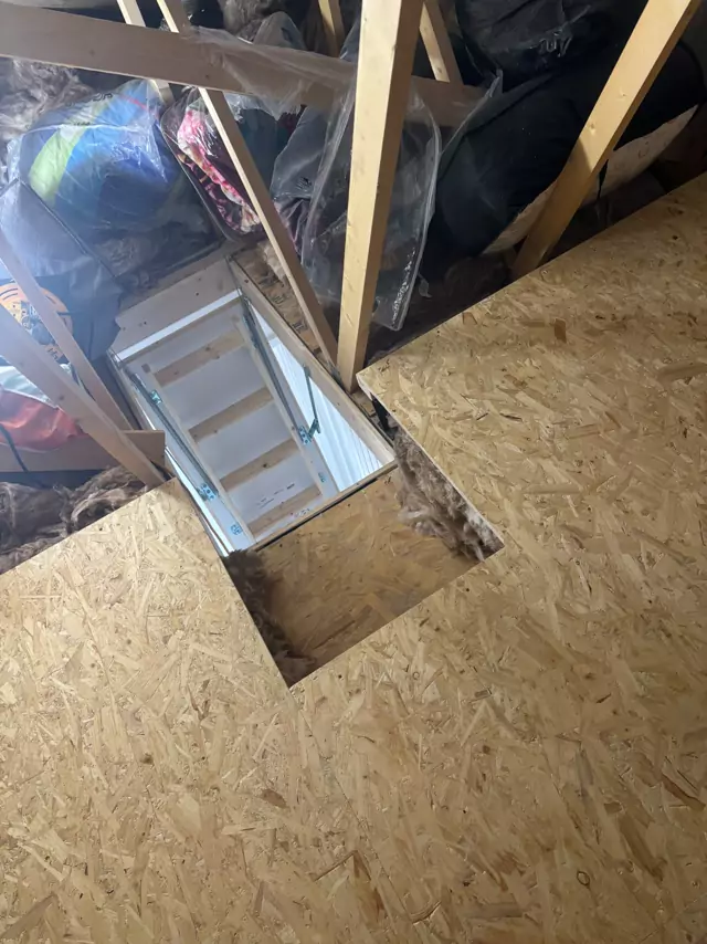 Boarding cut neatly round the hatch, white loft ladder below