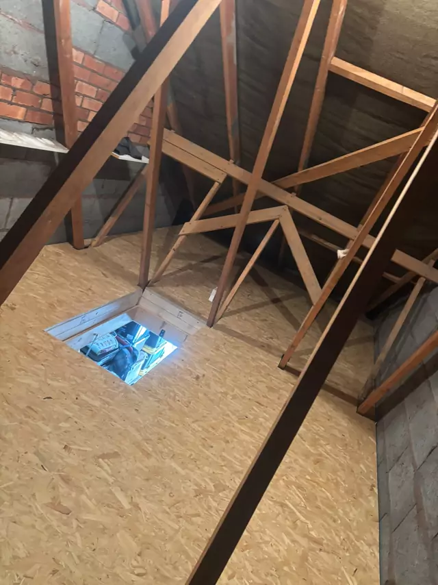 Boarded loft with a framed hatch opening and diagonal bracing