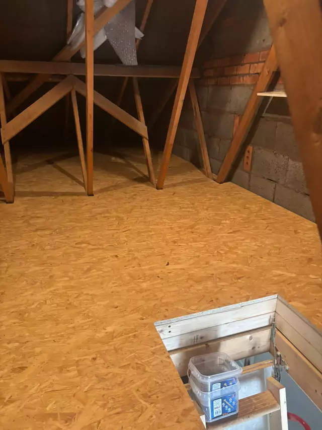 Boarded loft with a timber-lined hatch and storage below