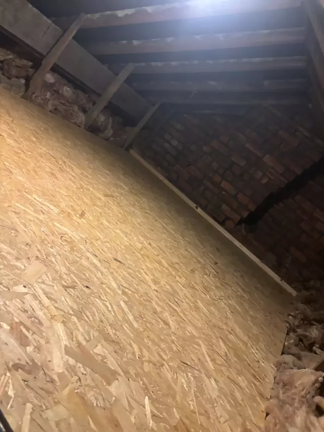 Boarded floor running into the eaves of an older brick loft