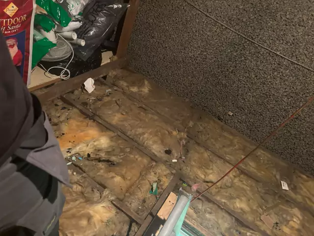 Before: old insulation and debris across the joists