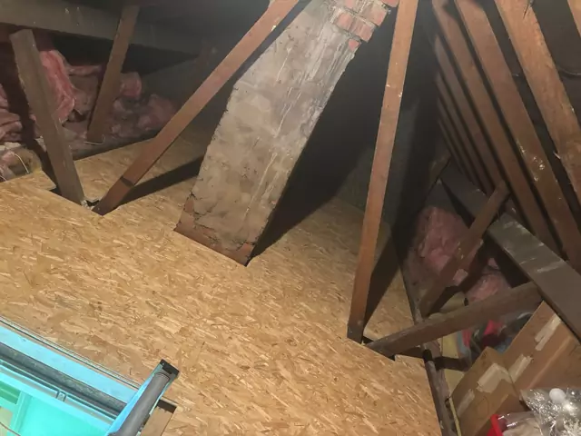After: The same loft boarded round the chimney stack