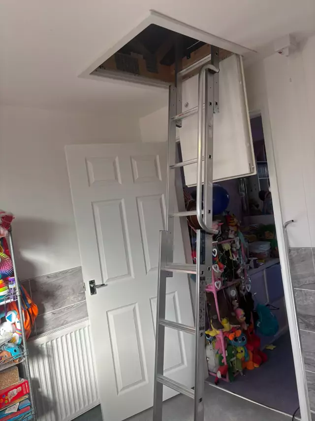 Aluminium loft ladder down from a new hatch in a bedroom