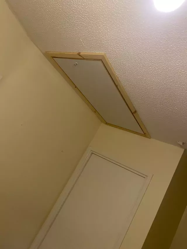 New hatch framed into a sloping ceiling above a stair