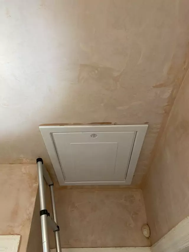 White hatch door closed above the ladder